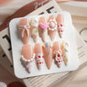 Birthday press-on nails with 3D bows and strawberry cake design from Joyee Nails