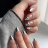 Silver chrome French tip press-on nails on medium almond shape — mirror-metallic tips over a sheer nude base, the defining chrome nail design trend for 2026, handmade by Joyee Nails.