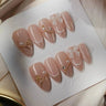 Coquette nails with champagne glitter finish and delicate bow accents on press-on nails by Joyee Nails