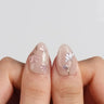 Nude nail designs on almond press-on nails with hand-painted white floral accents by Joyee Nails
