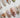 White press-on nail designs from Joyee Nails — milky white, pearl white, chrome white, and bridal French tip styles arranged on a neutral background