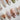 White press-on nail designs from Joyee Nails — milky white, pearl white, chrome white, and bridal French tip styles arranged on a neutral background