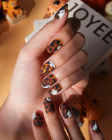 Peek-a-Boo press on nails with little white ghosts peeking out on a matte amber tortoiseshell base - image 1