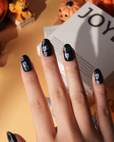 Party Spirits press on nails with holographic teal, lilac and pink glitter ghosts on a glossy black base - image 1