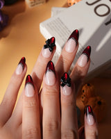Vampire Lace press on nails with blood red French tips, hand-painted black lace trim and a 3D black bow on a nude base - image 1