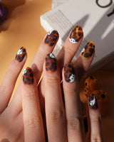 Peek-a-Boo press on nails with little white ghosts peeking out on a matte amber tortoiseshell base - image 3
