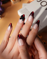 Vampire Lace press on nails with blood red French tips, hand-painted black lace trim and a 3D black bow on a nude base - image 5