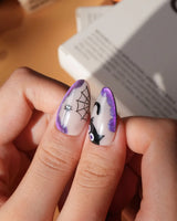 Witching Hour press on nails with a black spider web, bats, ghost, black cat and jack-o'-lanterns on a nude base with purple glitter edges - image 5