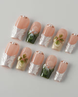 Duchess Olive nail close-up with olive French styling and dimensional flower details