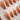 Caramel Chrome press-on nails with nude base, brown French fade, and mirror-like gel shine