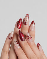 Crimson Petals press-on nails with deep red French tips and gold outlined floral accents