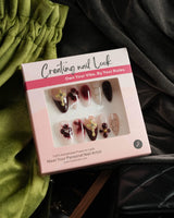 Tip Burgundy Nails press-on set with red French tips, gold cross charms, and floral details