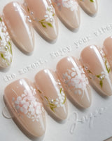 First Vow handmade press-on nails featuring Gentle Milk Tea Nude, Hand-painted White Florals & Pearl Accents.