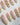 First Vow handmade press-on nails featuring Gentle Milk Tea Nude, Hand-painted White Florals & Pearl Accents.