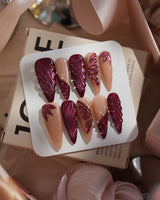 Velvet Flow press-on nails with metallic outlined butterfly wings and glossy berry red gel