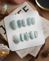 Dead Sea Blue handmade nails styled with luminous seafoam shell texture and pearl accents