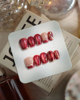 Molten Rouge press-on nails with deep red cat-eye, gold outline accents and glossy finish