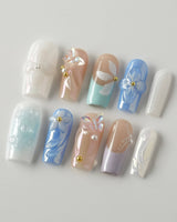 Aqua Petal medium square nails with pearly pastels, 3D flowers, and butterfly accents