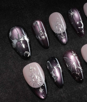 Arcana press on nails with sculpted silver sun, moon, star and key charms and a silver wing on plum and black cat eye with crystals - image 1