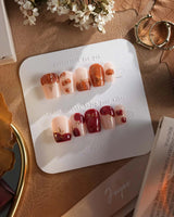 Autumn Bounty press-on nails with pumpkin patch accents, red apples and gold linework