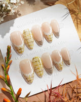 Tweed Light nail set with pale nude base, gold shimmer tips, and soft plaid accents