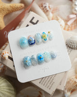 Bali Blue extra short squoval nails with tropical water ripples, 3D flowers, and starfish