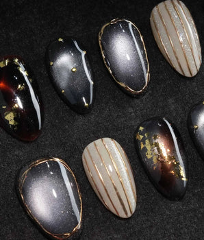 Black Lacquer press on nails with real gold foil in deep amber red and glossy black, gold studs and fine gold pinstripes on cream - image 1