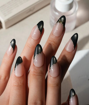 Black Tie press on nails with a black cat eye French tip edged in a fine gold line and a sculpted gold bow on a nude base - image 1