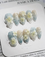 Bora Bora Blue serene ocean nails with icy blue cat-eye shine and 3D florals