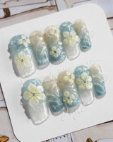 Bora Bora Blue medium square nails with cat-eye waves and white yellow floral sculpture