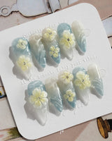Bora Bora Blue medium stiletto nails with smoky blue water shimmer and 3D flowers