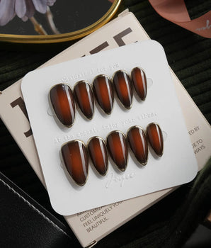 Bourbon press on nails in warm brown glossy jelly with a hand-drawn gold chrome outline - image 1