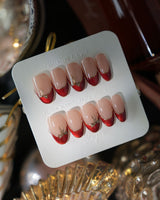 Bow French press-on nails in medium oval shape — nude base red chrome french gold outline bow accent