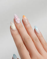 Candy Shore medium almond nails with coral stars, pastel seashells, and glossy gel