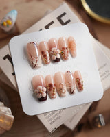 Caramel Cream in medium coffin shape with caramel brown 3D flowers and gold wire accents