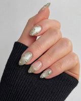 Clover Field press-on nails in short almond shape — Fresh Grass Green, Hand-painted Metallic Florals & French Pearl Outlines.