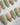 Clover Field press-on nails in short almond shape — Fresh Grass Green, Hand-painted Metallic Florals & French Pearl Outlines.