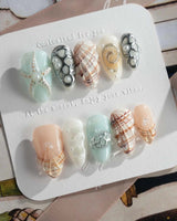 Coastline Edit moody summer nails with silver shells and brown-gold shimmer