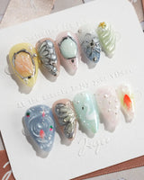 Como Blue short stiletto nails with pearly ripples, butterfly wings, and goldfish