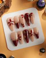 Crimson Petals press-on nails with red French tips, gold floral accents and glossy finish