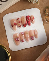 Crystal Berry press-on nails with glossy red cat-eye cherries and gold outlined nude nails