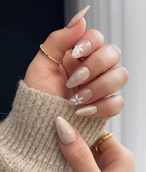 Spiral Twist press-on nails with pearly nude silk texture and delicate daisy accents