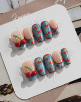 Denim Cherry handmade nails with nude base, denim blue accents, and glossy cherry art