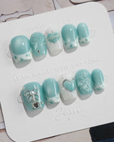 Exuma Blue extra short coffin nails with 3D hearts, jelly gloss, and silver sparkle