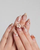 Caramel Cream press-on nails with warm brown base, sculpted flowers, and gold wire details