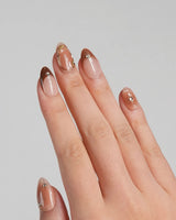 Fall Makeup nails with brown ombre base, metallic star accents, and delicate gem details