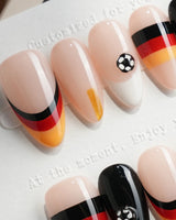 FIFA Germany short almond press-on nails with black, red, and gold soccer flag design