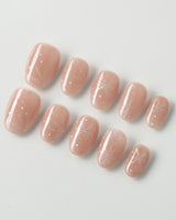 Frost Petals press-on nails in extra short oval shape — Sheer Nude Pink, Delicate White Snowflakes.