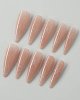Frost Petals press-on nails in long stiletto shape — Sheer Nude Pink, Delicate White Snowflakes.