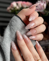 Frost Petals handmade press-on nails featuring Sheer Nude Pink, Delicate White Snowflakes.